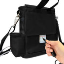 Hand connecting power to black portable oxygen concentrator bag with shoulder strap