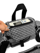 Hand opening houndstooth carry bag with Inogen One portable oxygen concentrator inside