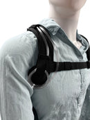 Person wearing black oxygen backpack harness with clear nasal cannula tubing on shoulder