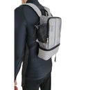 Person wearing a dark grey mesh oxygen concentrator backpack with side pocket and zippers